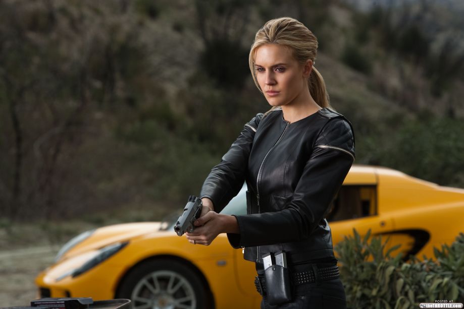 sexy girl in black leather and gun in front of Lotus Elise