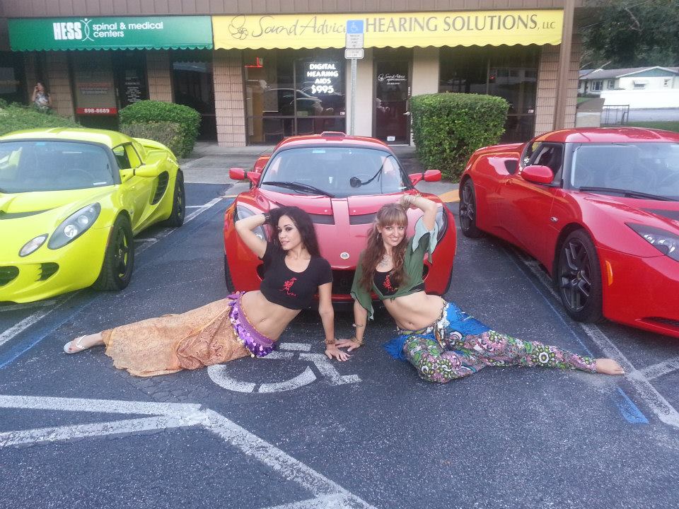belly dancers in front of a lotus elise